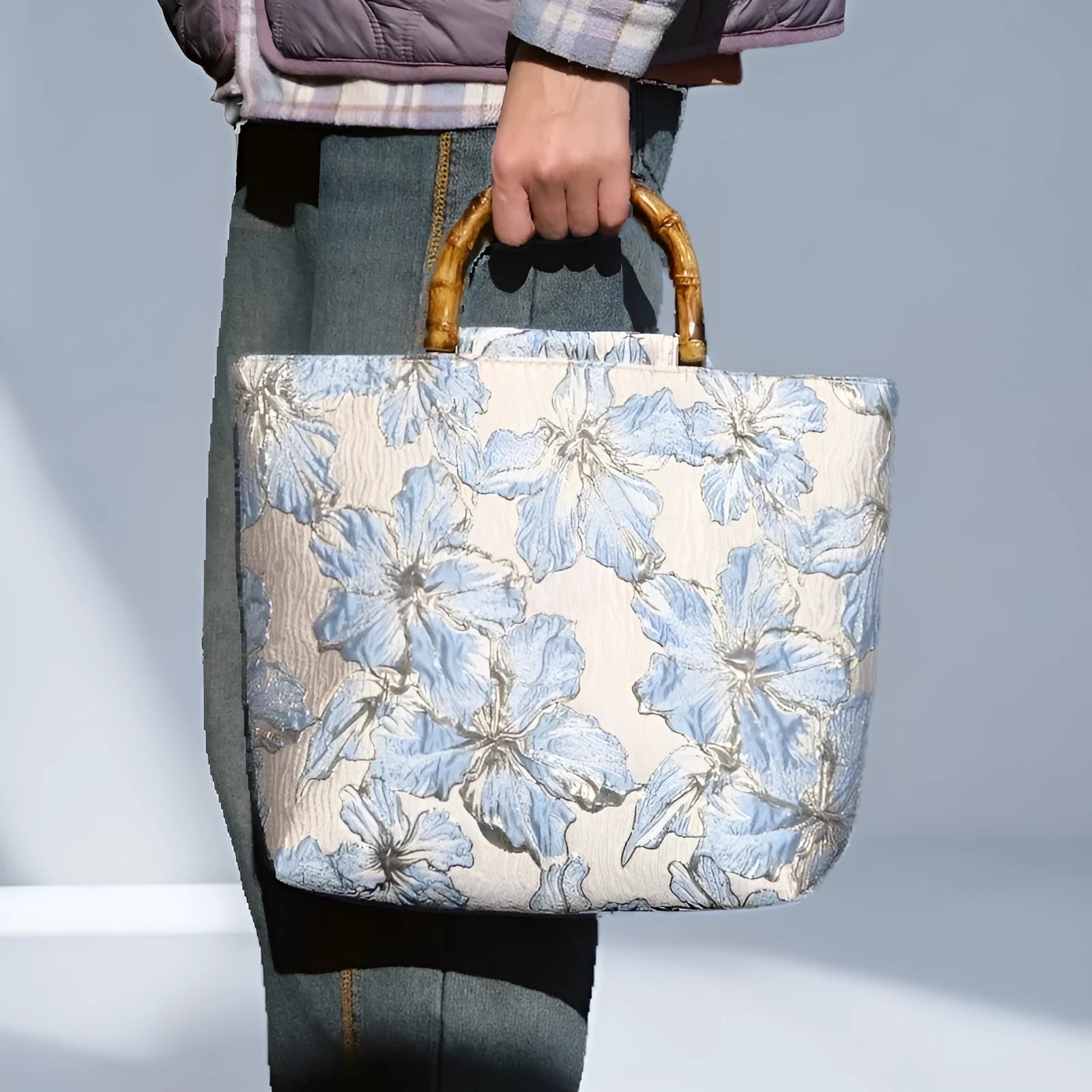Light blue canvas bag with gold bronzing flower pattern, horizontal square shape, and dual shoulder straps.