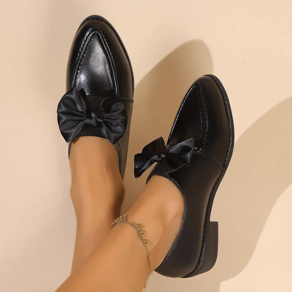 Women's pointed toe shoes with a choice of large buckle bow or small bowknot detail on a PU leather upper.