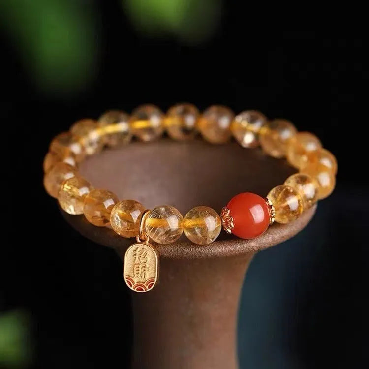 Natural red agate lucky beads bracelet with gold ruby accents on a wrist.
