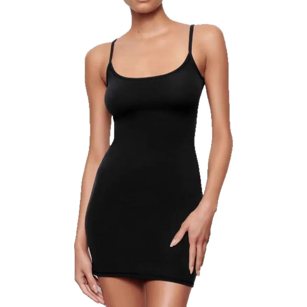 A black skinny sheath dress with a sling neckline and short mini length on a model.