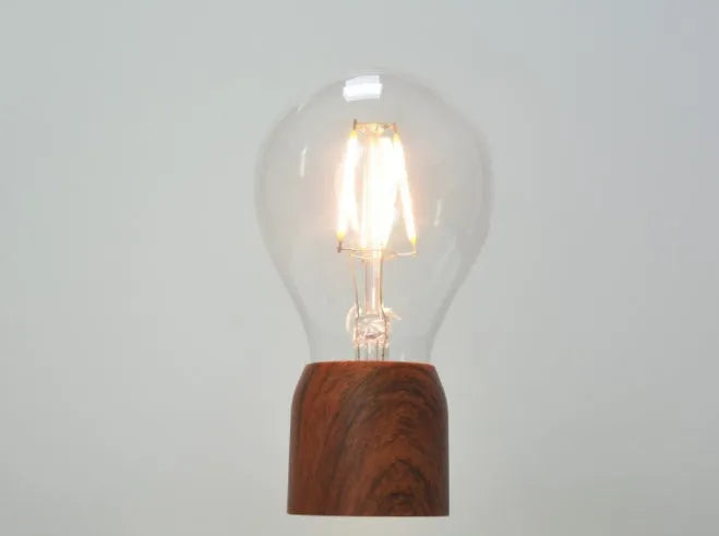 Magnetic levitation floating light bulb with imitation wood base.