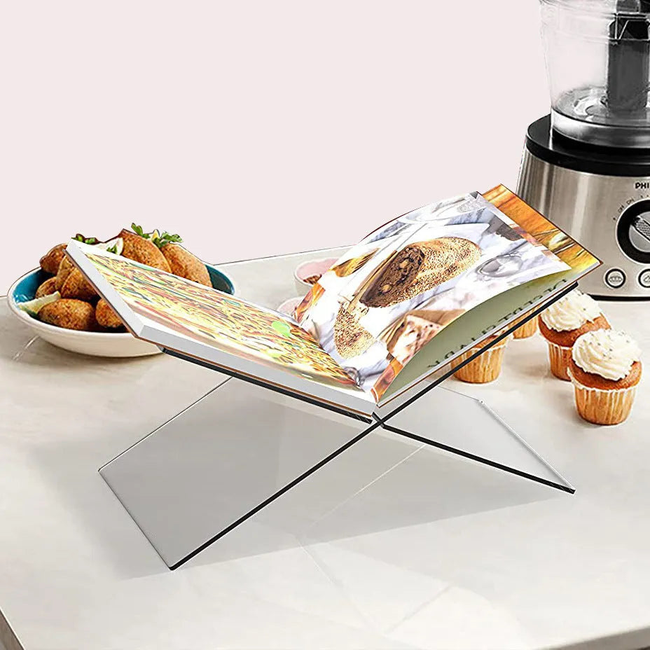 Clear acrylic X-shaped book display rack holding several upright books on a desk