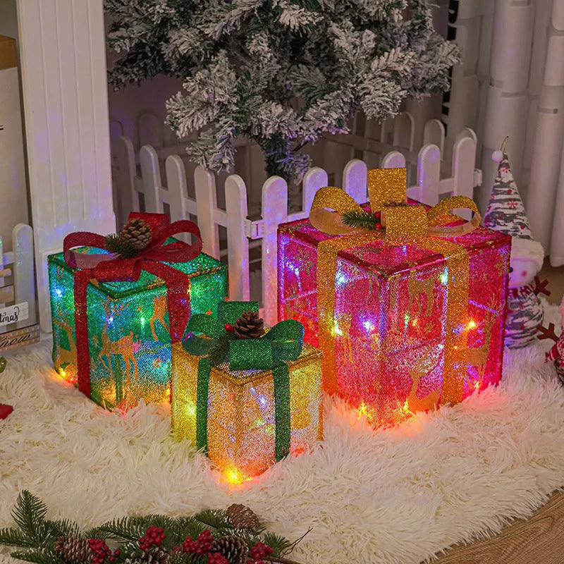 Set of three lighted Christmas gift box decorations with bows for outdoor holiday decor