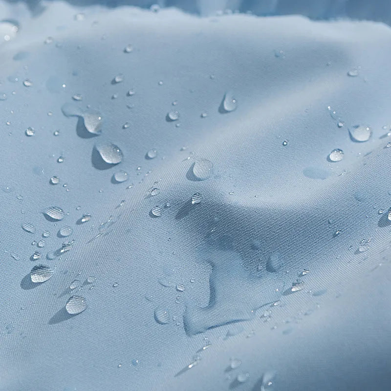 Loose thick polyester cotton-padded jacket in light blue on a hanger showing side seam pockets.