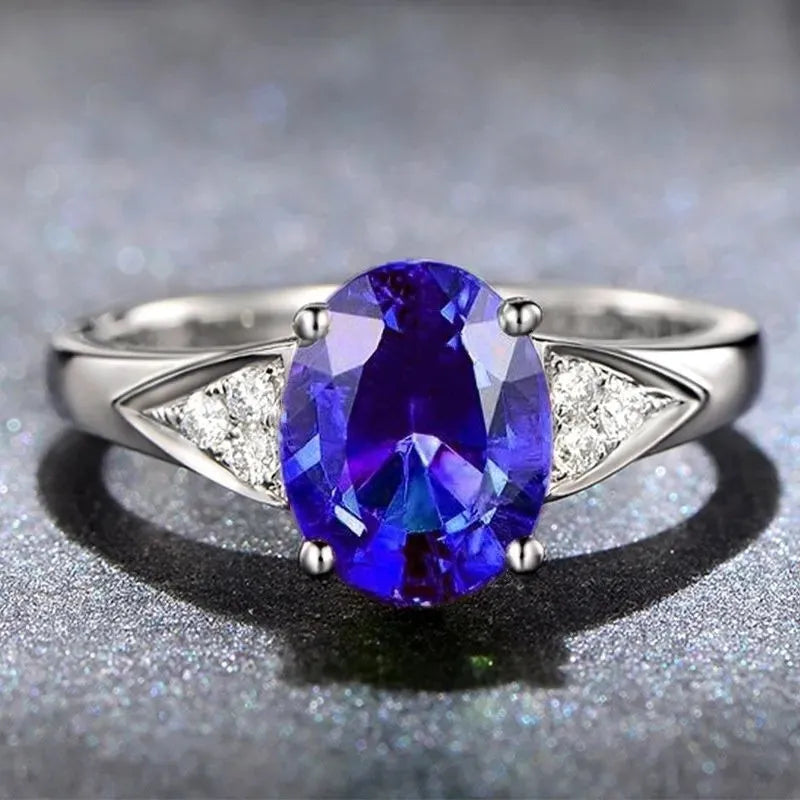 A women's sterling silver ring with a geometric pattern of inlaid red and blue natural zircon stones on a comfort-fit band.