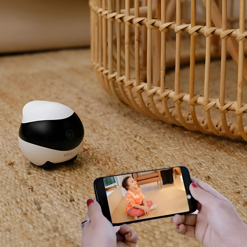 White compact mobile surveillance robot camera on a charging dock.