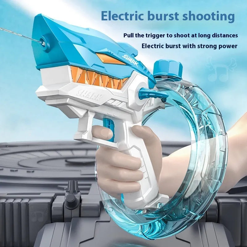 Blue Shark-shaped electric water gun toy with large tank on a sandy beach