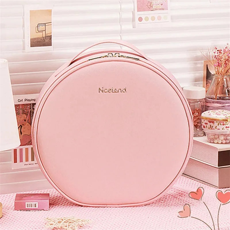 Round pink PU leather makeup bag open showing illuminated mirror and internal partitions.