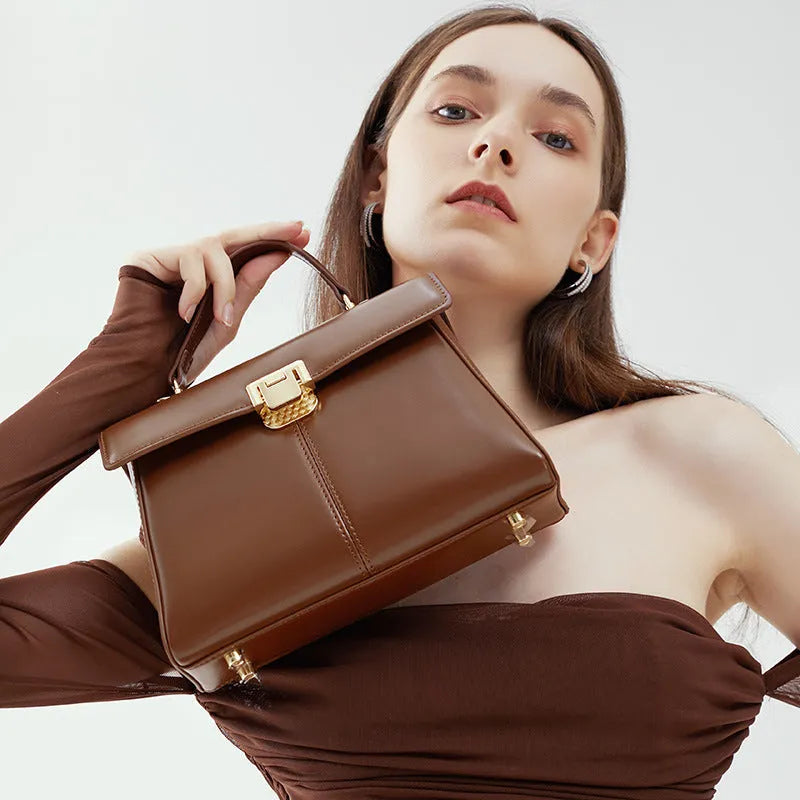 Black genuine leather women's shoulder bag with vachette clasp, showing horizontal square shape and adjustable strap.