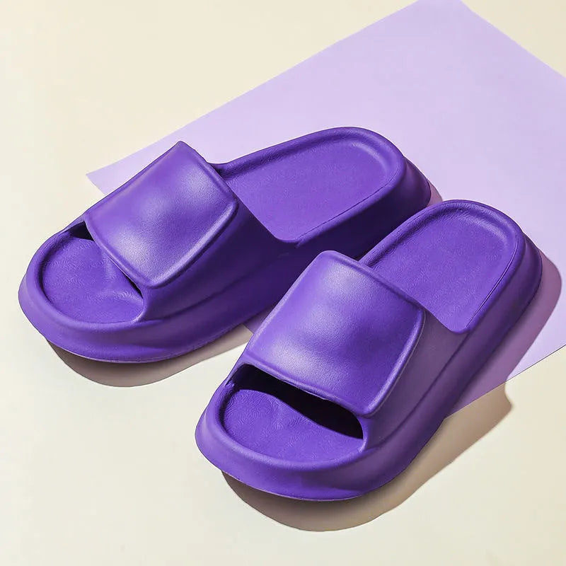 Pair of white EVA flip-flop slippers with a thick, textured sole on a tiled floor.