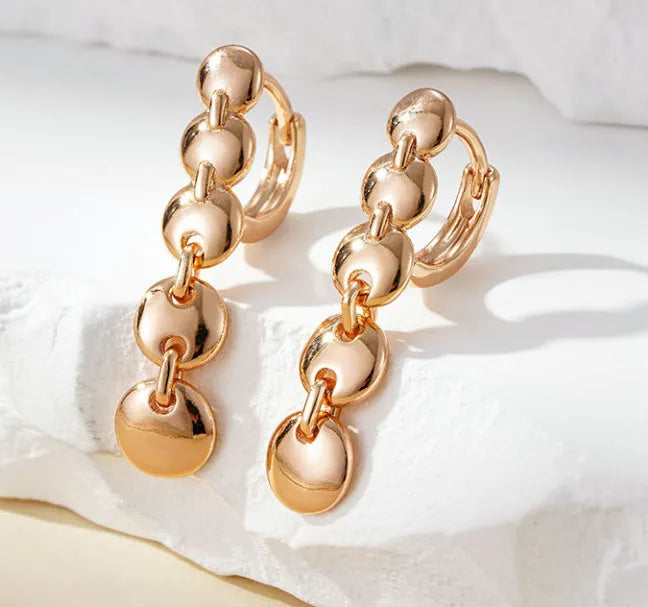 A pair of gold-coloured retro long round circle earrings with a woven copper design.