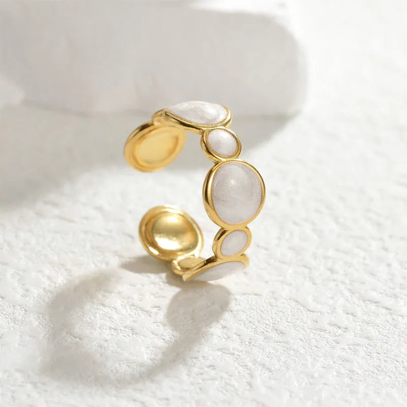 Adjustable geometric ring in stainless steel with a light luxury electroplated finish on a grey background.