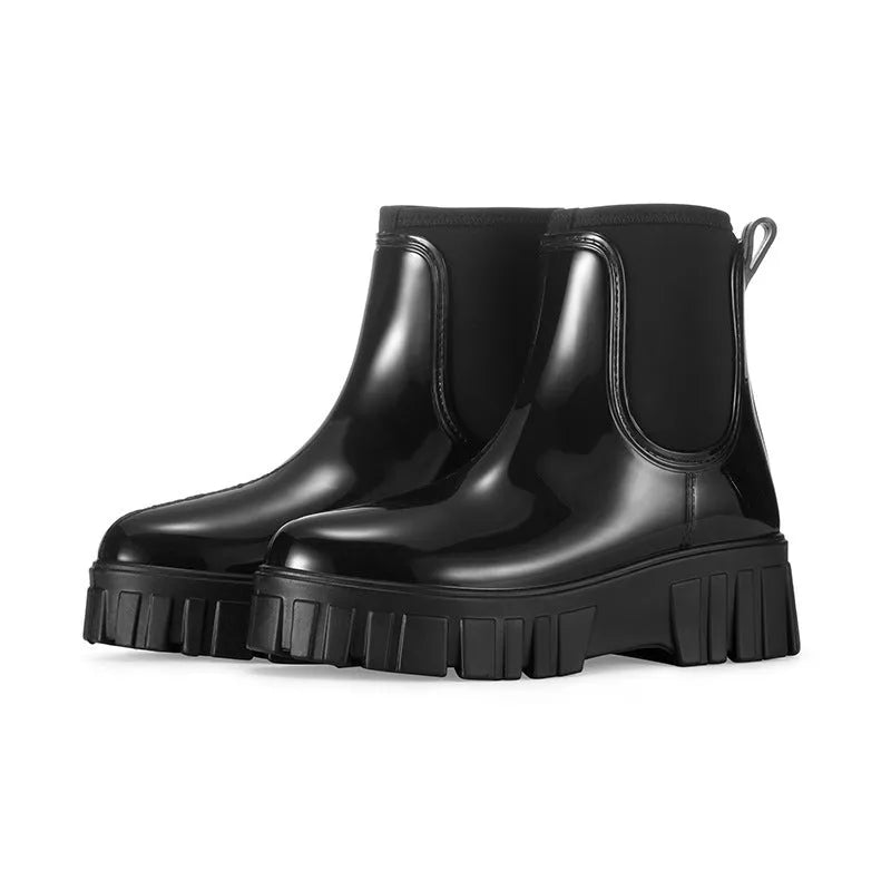 A pair of low tube, flat-heeled PVC rain boots in a solid colour.