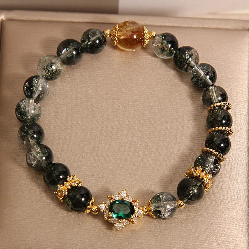 Gold rutilated quartz bracelet with green phantom quartz and ruby quartz crystal beads, pearl accents, and gold-plated detailing
