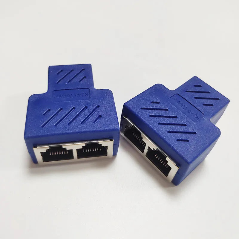White RJ45 three-way tee network cable splitter adapter on a table.