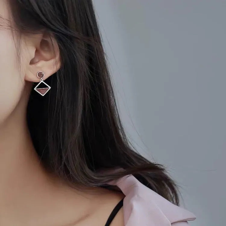 925 silver asymmetrical love earrings with frosty electroplated brown finish on a light background