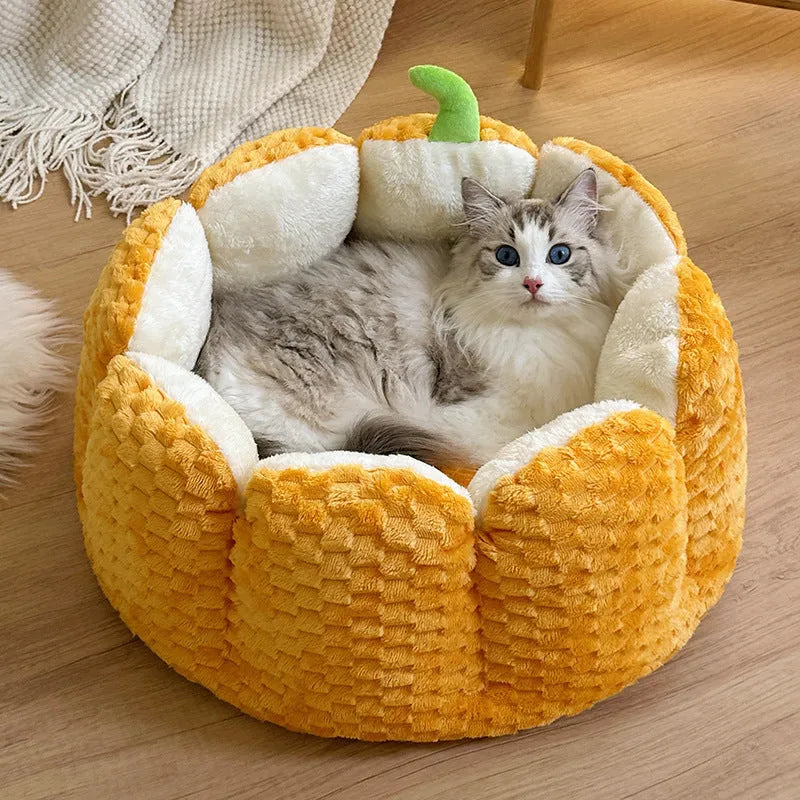 Orange pumpkin-shaped pet bed nest for cats and small dogs on a wooden floor.