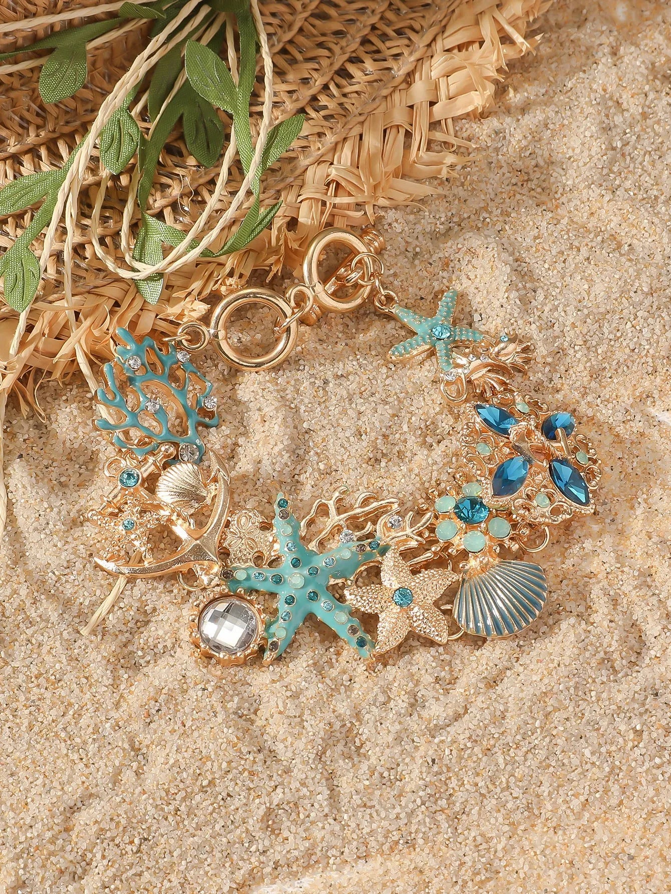 Alloy rhinestone bracelet with boat anchor, shell, and starfish charms in turquoise, red, or blue.