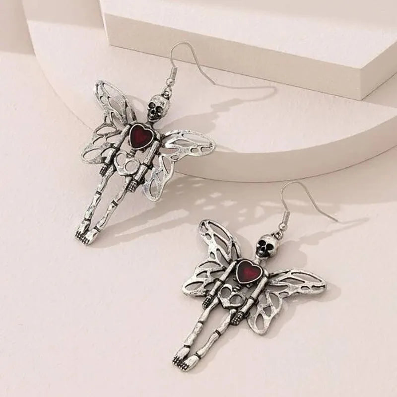 Pair of silver-coloured alloy earrings with exaggerated skull design on white background
