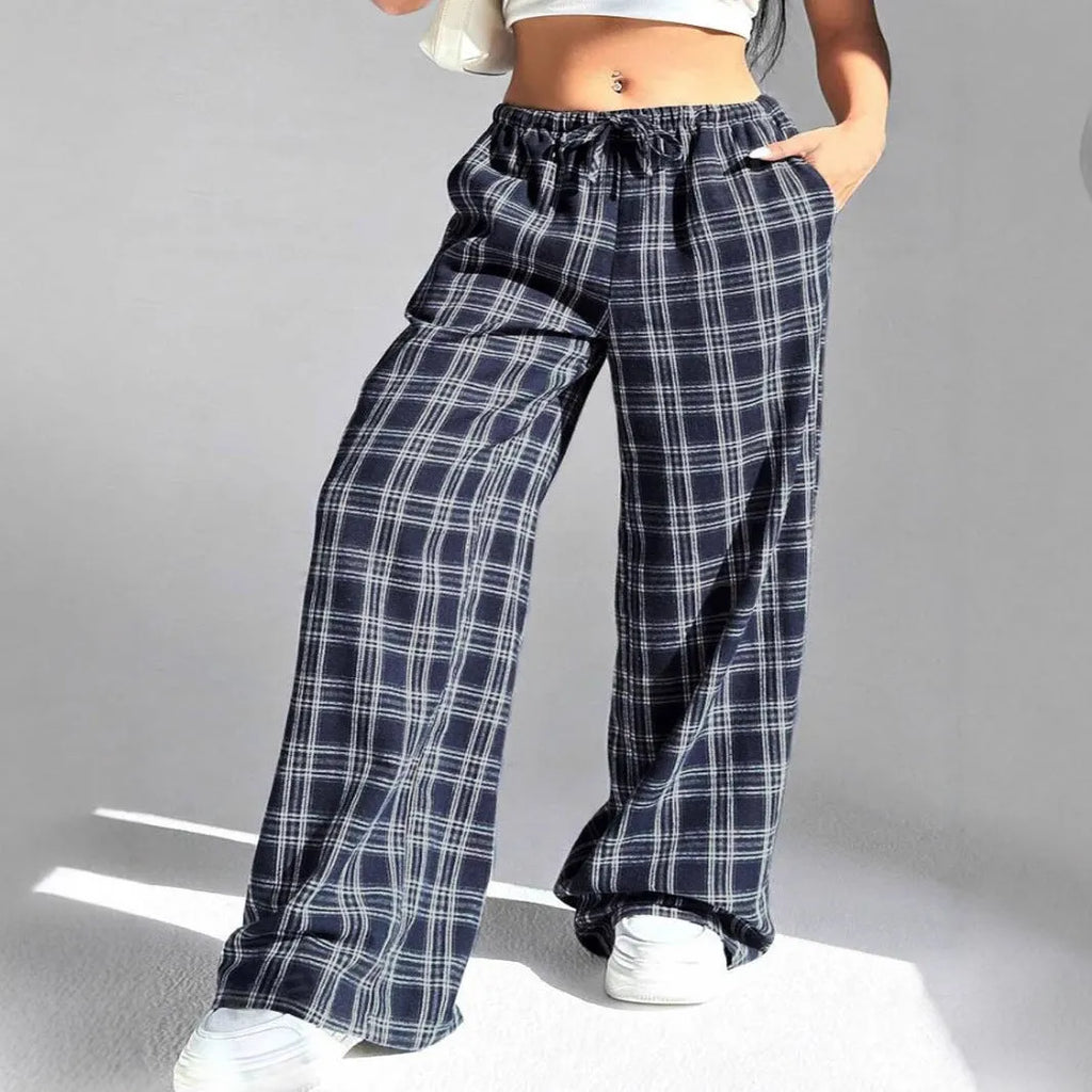 Blue women's loose fit casual trousers with a drawstring waist and front pockets on a hanger.