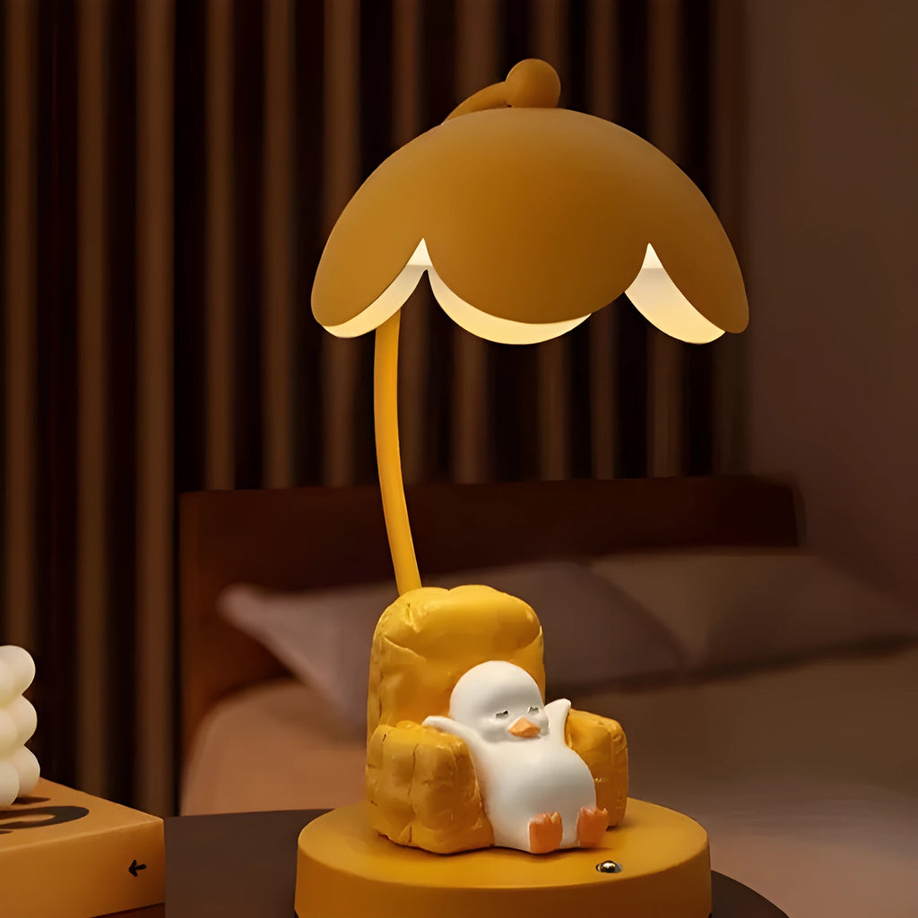 Cute yellow duck plastic night light table lamp with USB cable and gift box on a modern desk