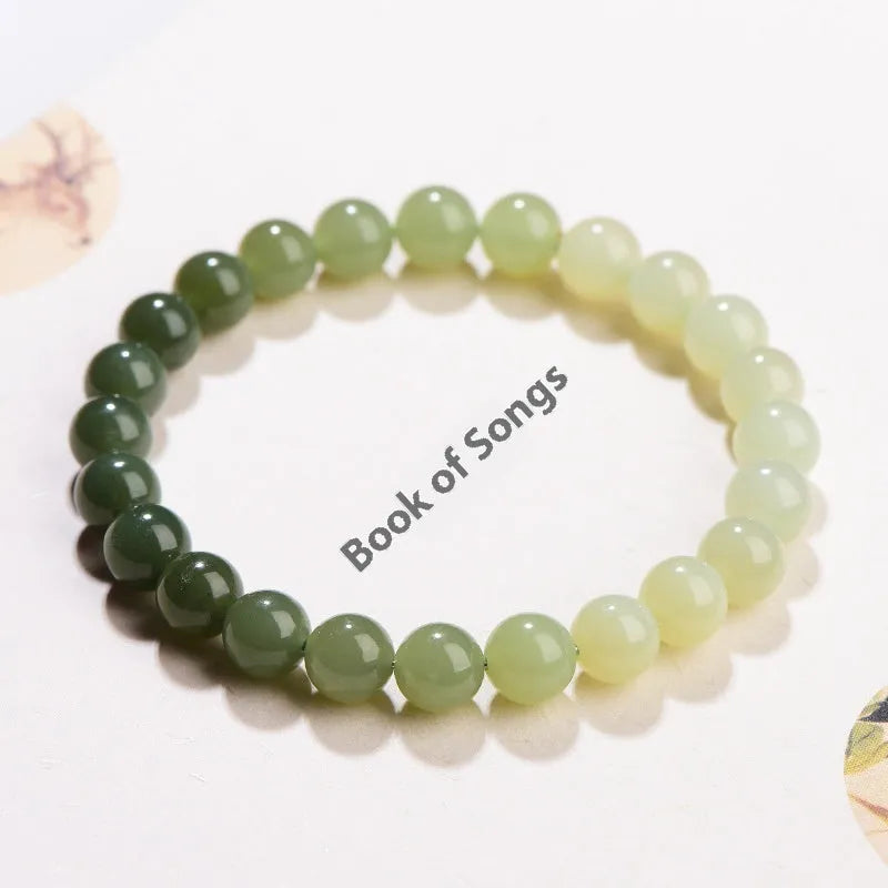 Natural Hetian jade bracelet with gradient clear water colour beads on a wrist.