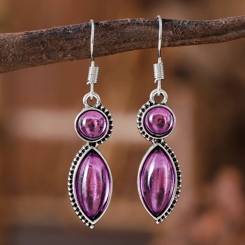 A pair of vintage-style geometric drop earrings with a round detail in black and purple electroplated zinc alloy.