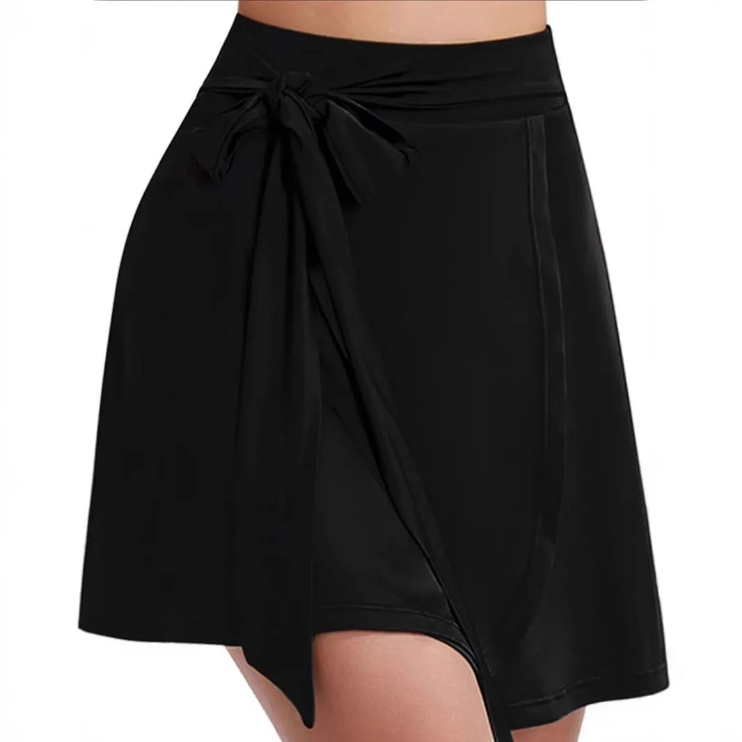 Black thigh-length sports skirt with built-in shorts, high waist, and shoulder straps laid flat.