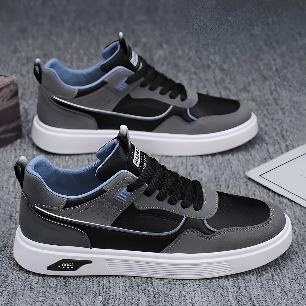 Men's low-top canvas board shoes in grey with leather stitching detail on a white background.