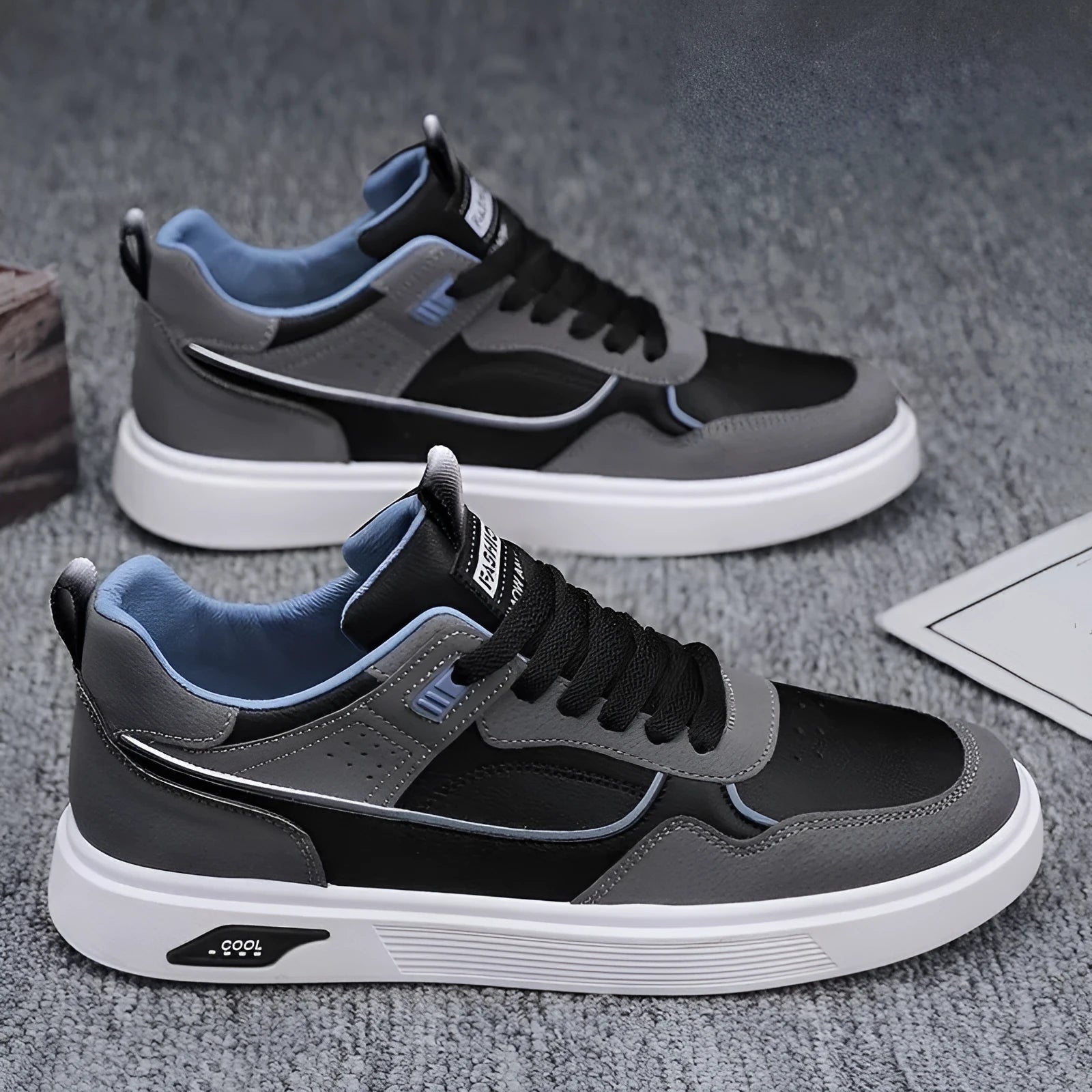 Men's low-top canvas board shoes in grey with leather stitching detail on a white background.