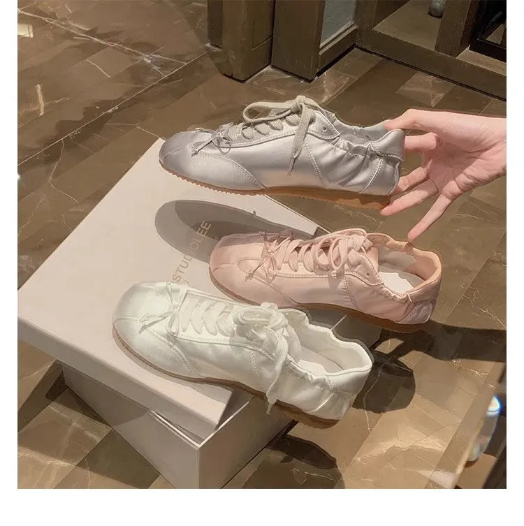 Women's satin ballet flat shoes with round toe and lace-up front in champagne pink colour