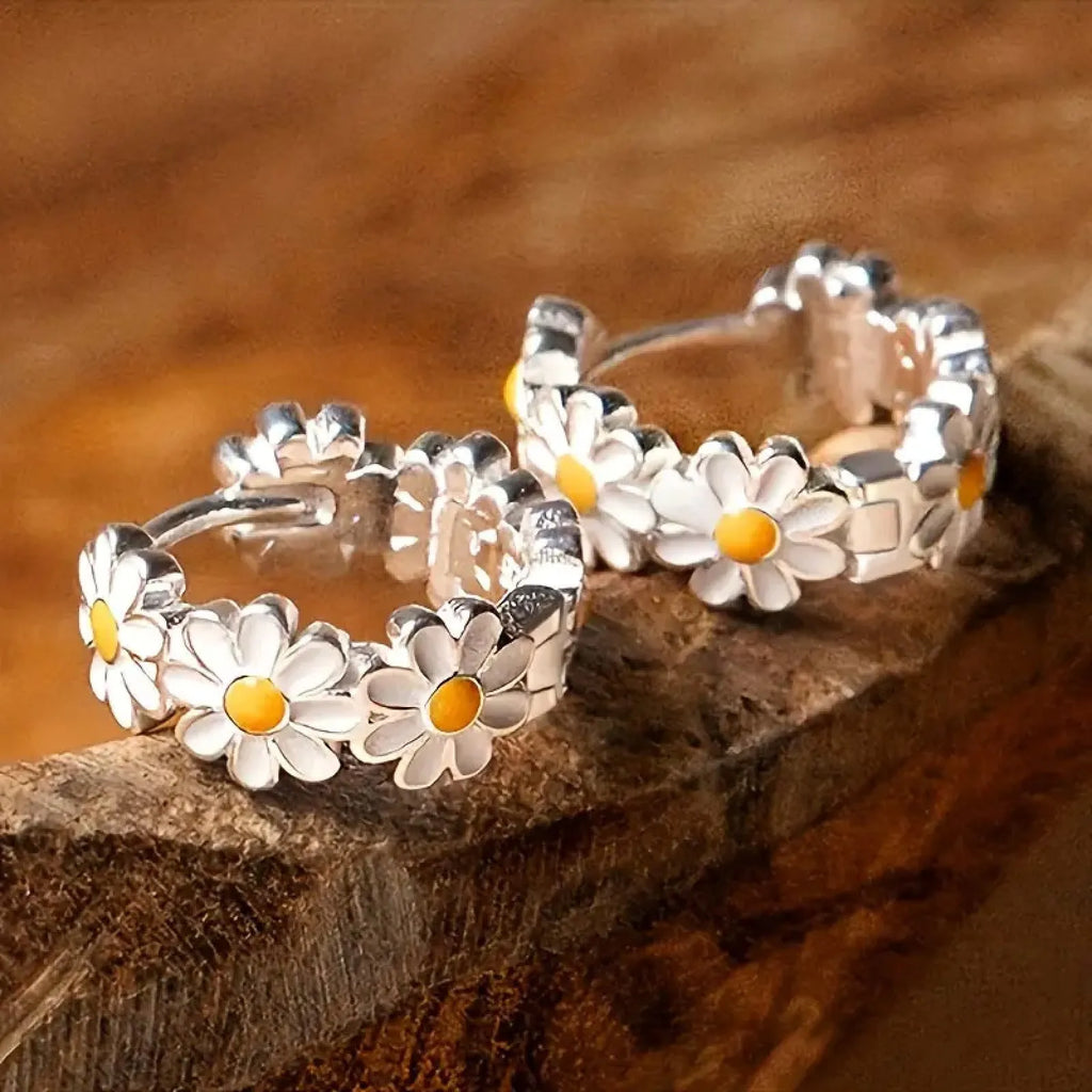 White electroplated copper daisy flower earrings with platinum gem inlay on white background