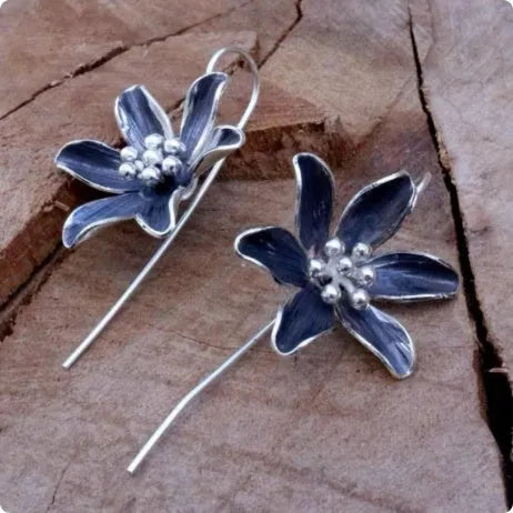 A pair of purple floral alloy earrings with a retro design on a white background.