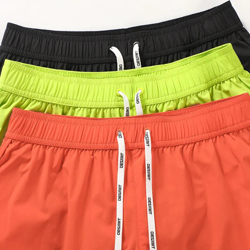 Men's loose beach shorts in orange, fluorescent green and black colours with elastic waistband