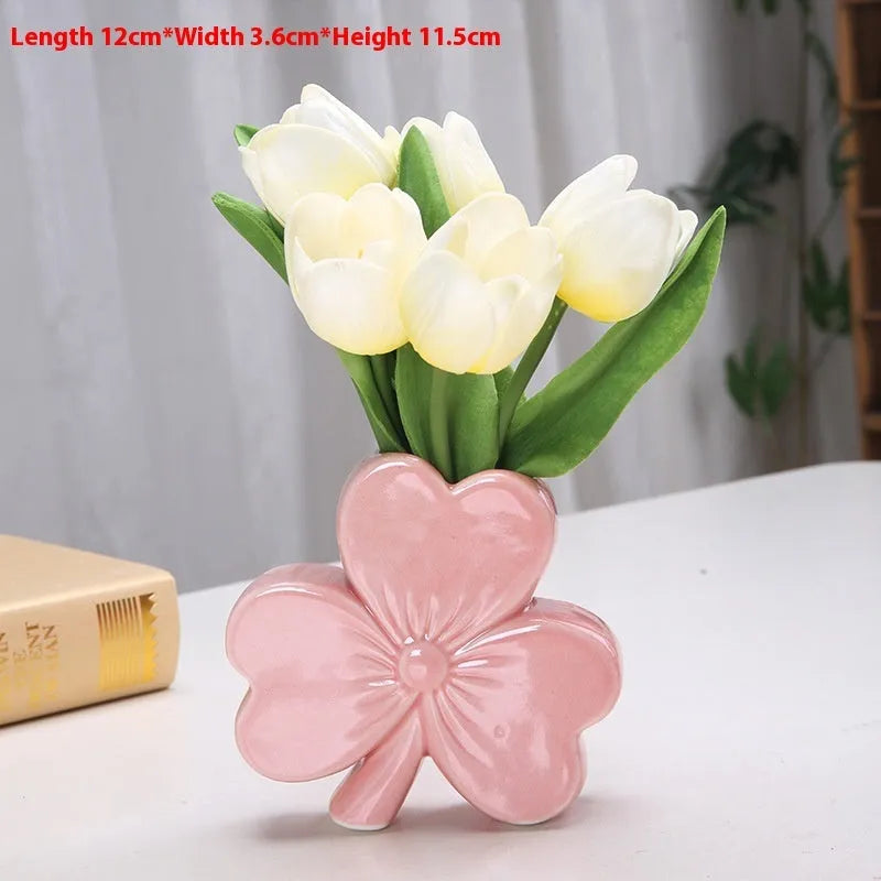 Small European-style ceramic vase in pink on a wooden desktop.