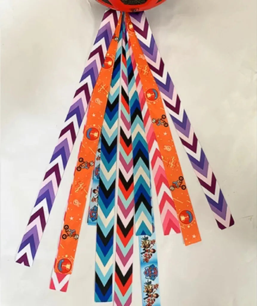 A decorative ribbon streamer for attaching to a child's roller skate or ski helmet, shown in a selection of colours.