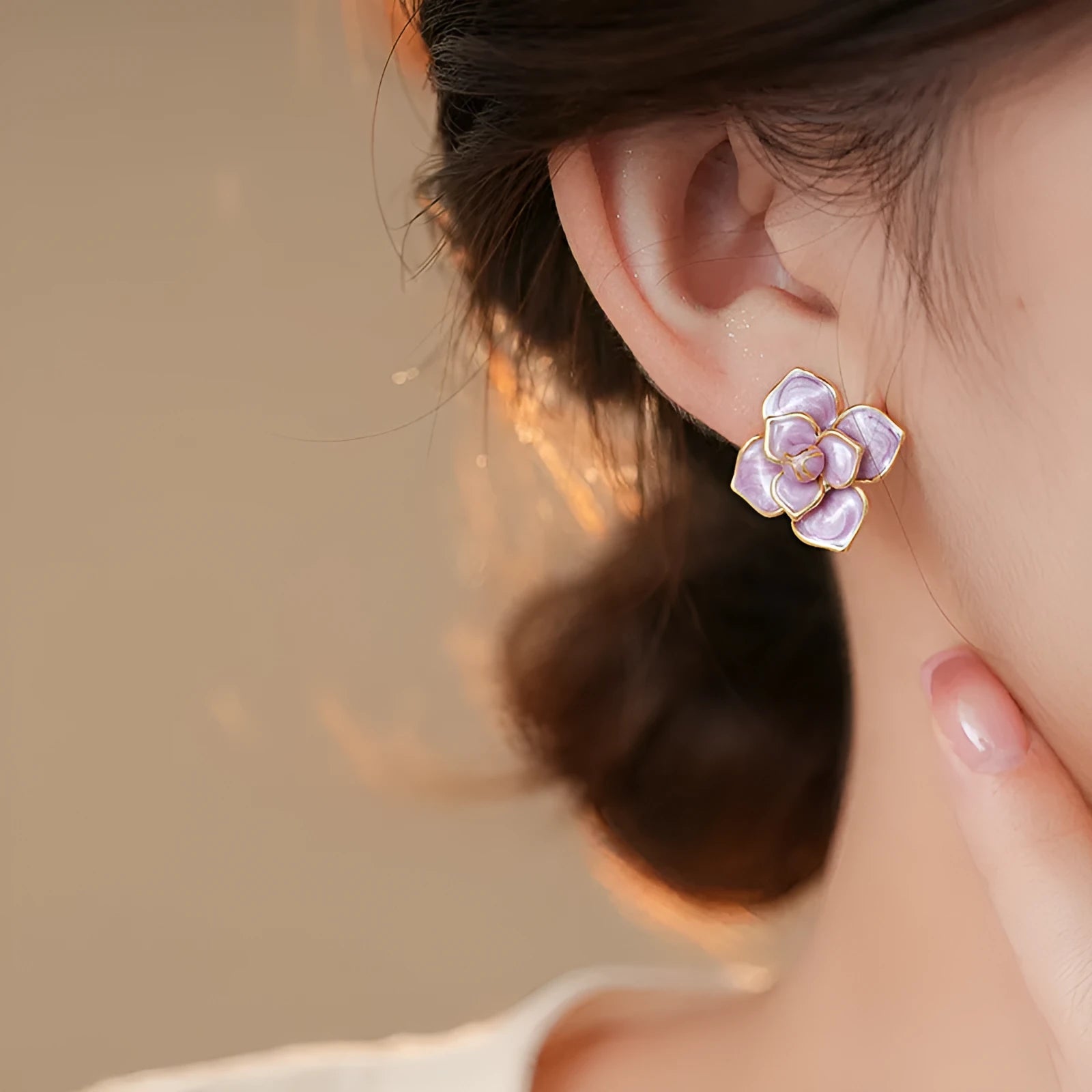 Gold plated stud earrings with a purple oil-spot glaze flower design on a copper base.