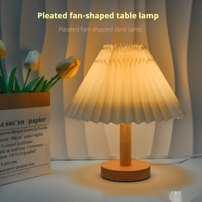 Vintage pleated umbrella-shaped USB bedside lamp with remote control on a wooden table.