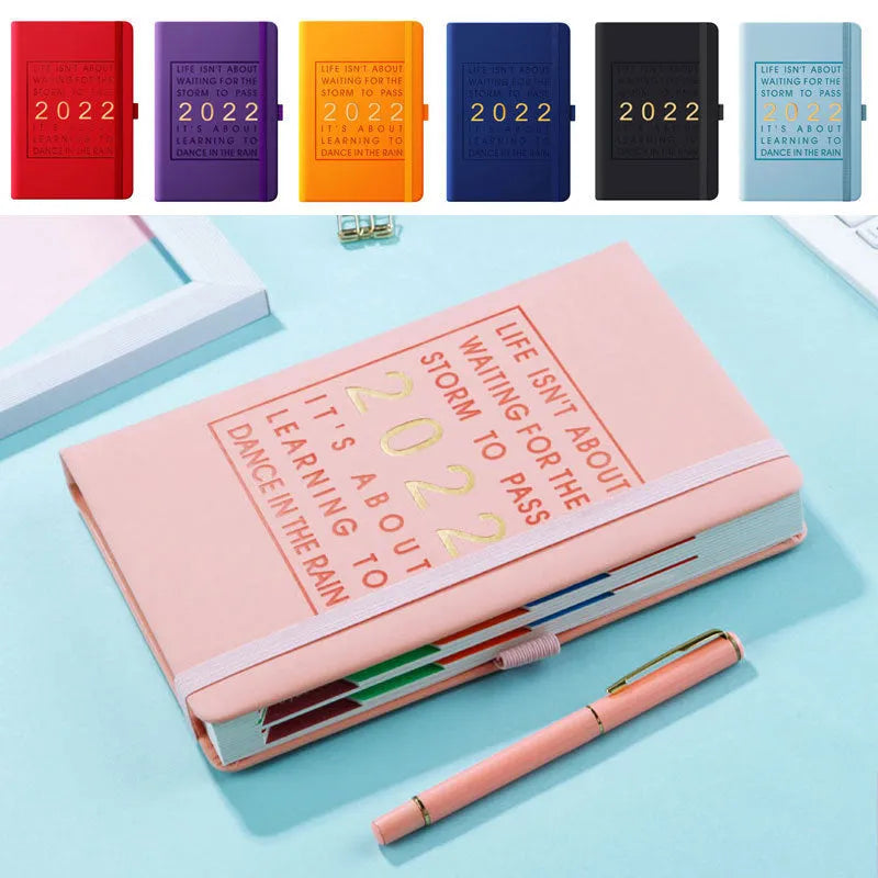 A5 imitation leather notebook with French fold binding open flat on a desk, seven colour options