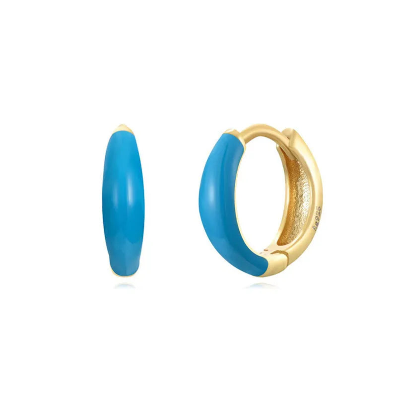 A pair of oval-shaped epoxy resin earrings on a U-shaped curved silver hook, showing a marbled colour finish.