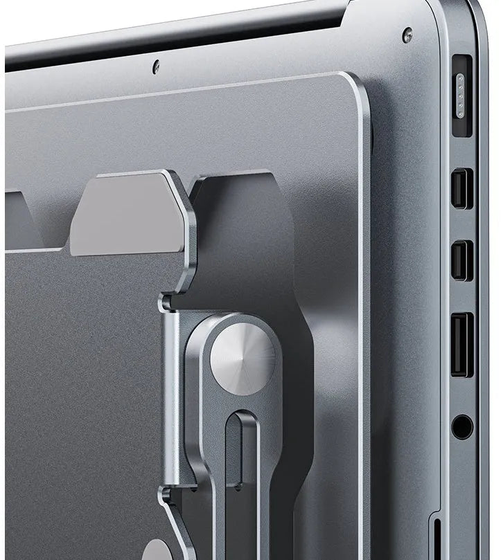 Grey aluminium folding laptop stand shown at an adjustable angle on a wooden desk.