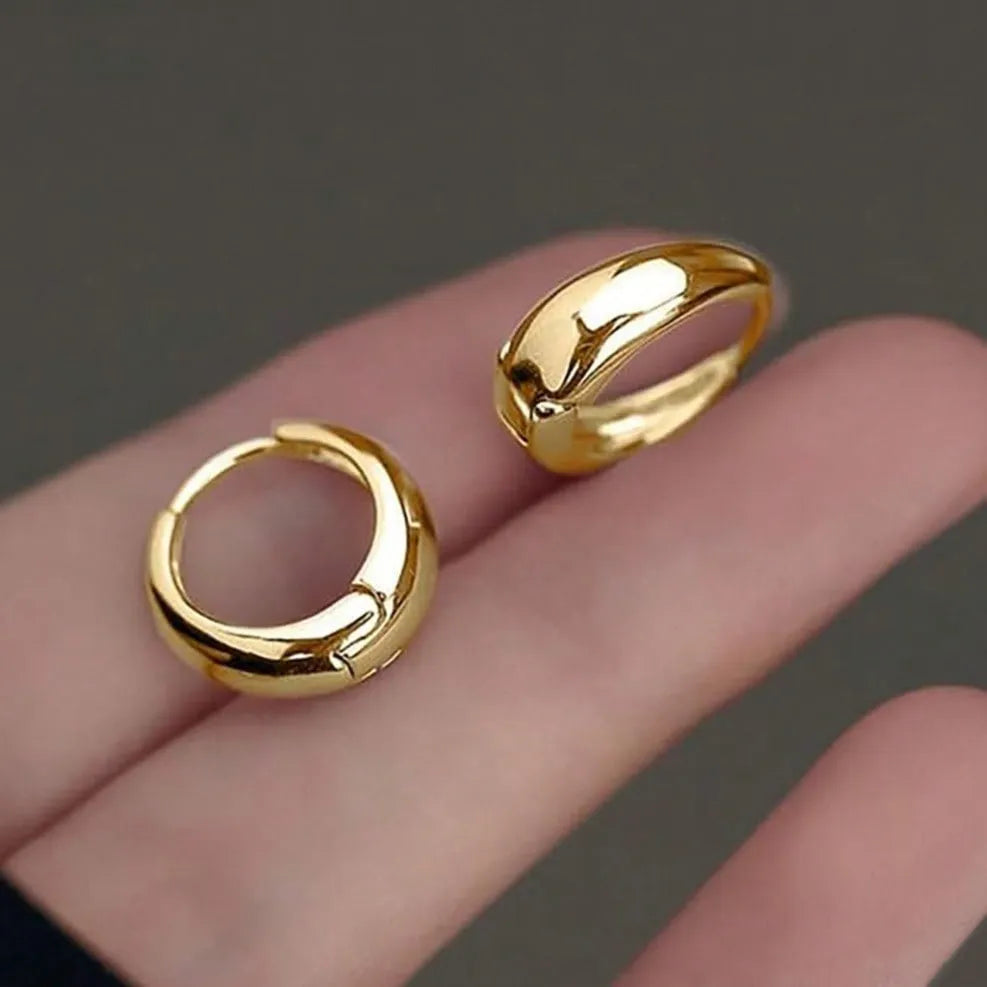 Three pairs of gold electroplated copper earrings with geometric ring design on a white background