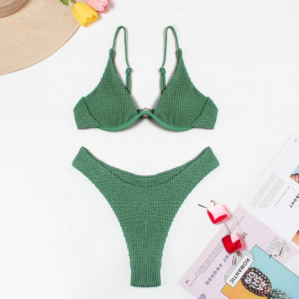 Women's solid green bikini suit with ruffle trim and split leg briefs on a mannequin.