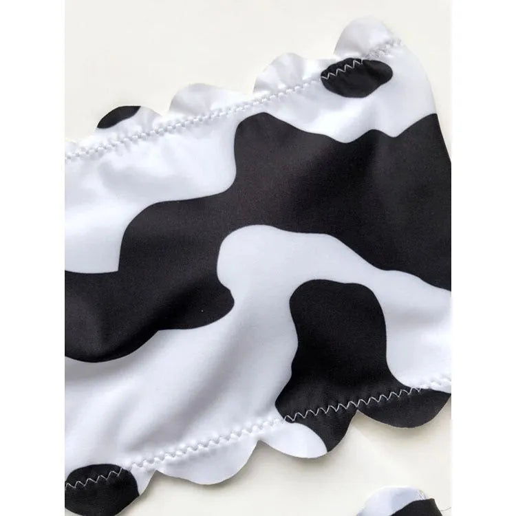 Black and white cow print wrapped breast bikini set on a model, nylon fabric, black and white animal pattern, adjustable wrap front top