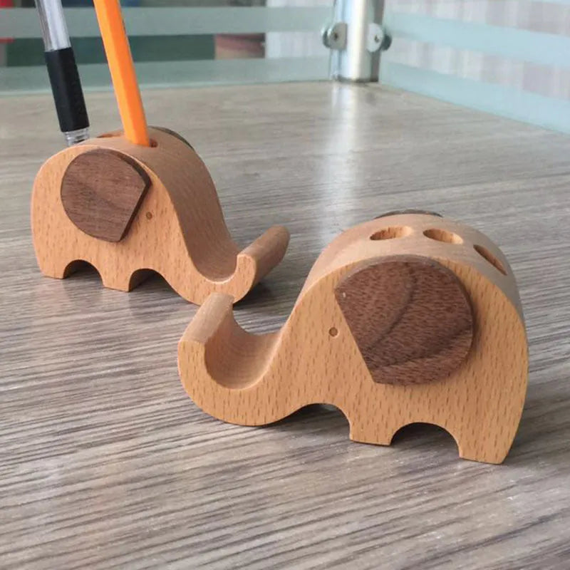 Sculpted beech wood lazy bracket phone holder with custom engraved text on a wooden desk.
