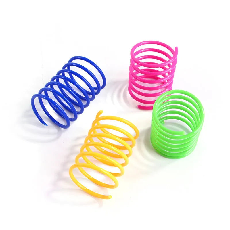 Colourful plastic coil spring toys for cats on a wooden floor.