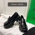 A pair of wide fit patent leather loafers with a flat rubber sole on a neutral background.