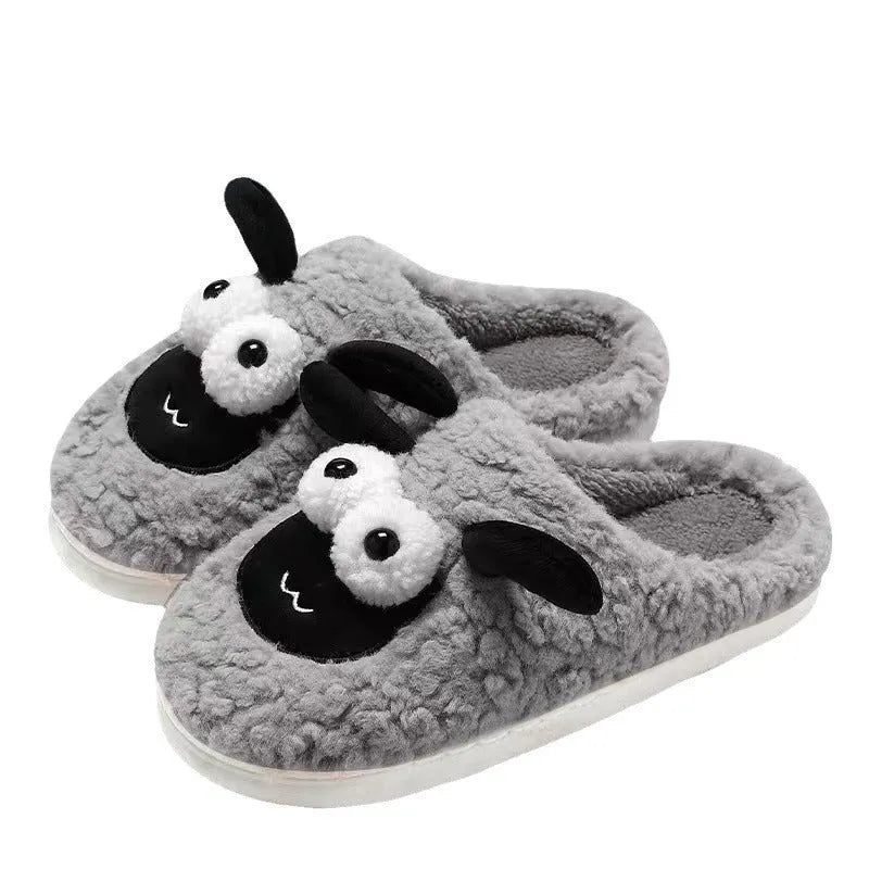Brown suede slip-on slippers with a PVC sole on a wooden floor.