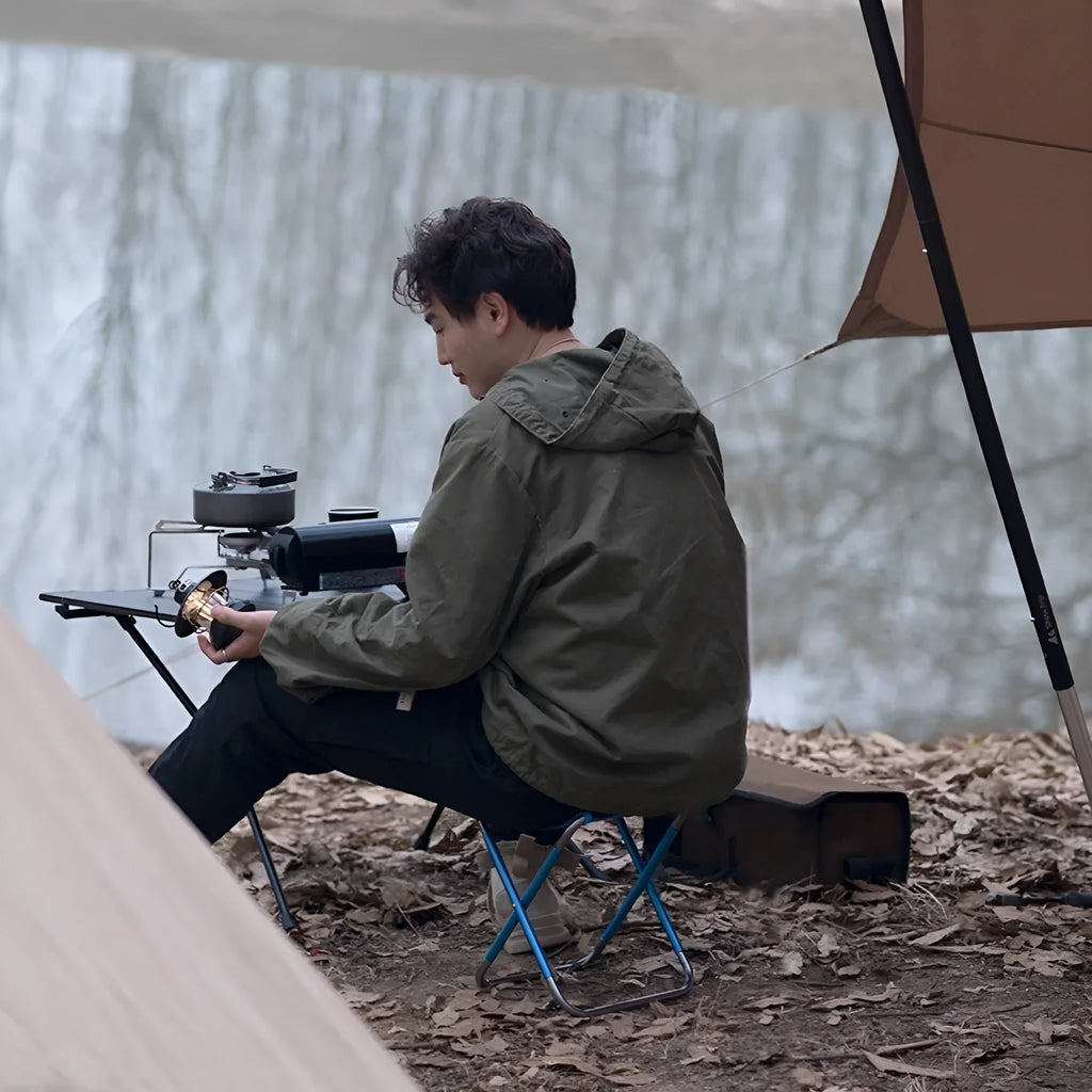 Black folding camp stool with aluminium alloy frame shown in open and folded positions.