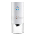 Black and white portable USB-C electric coffee grinder with transparent chamber on a kitchen counter